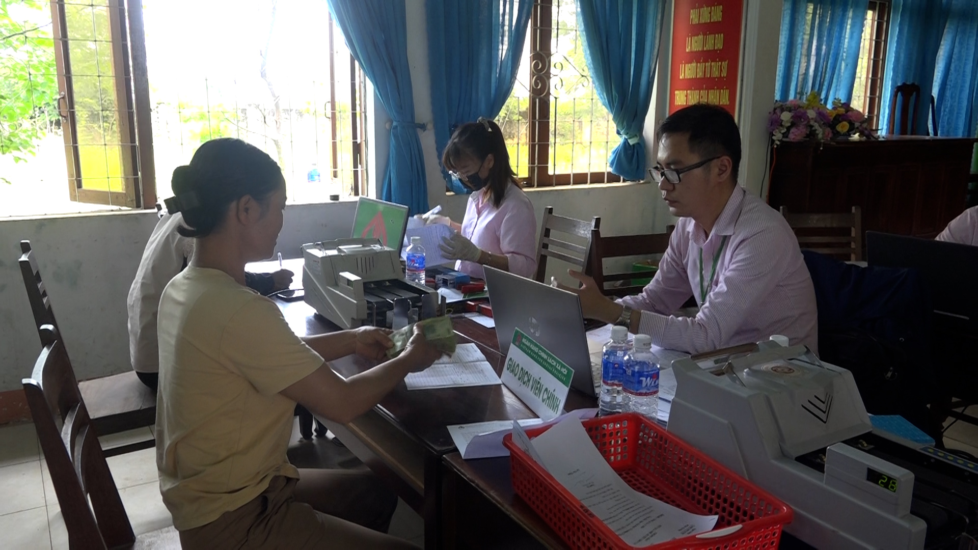 Cán bộ NHCSXH giải ngân vốn vay cho phụ nữ